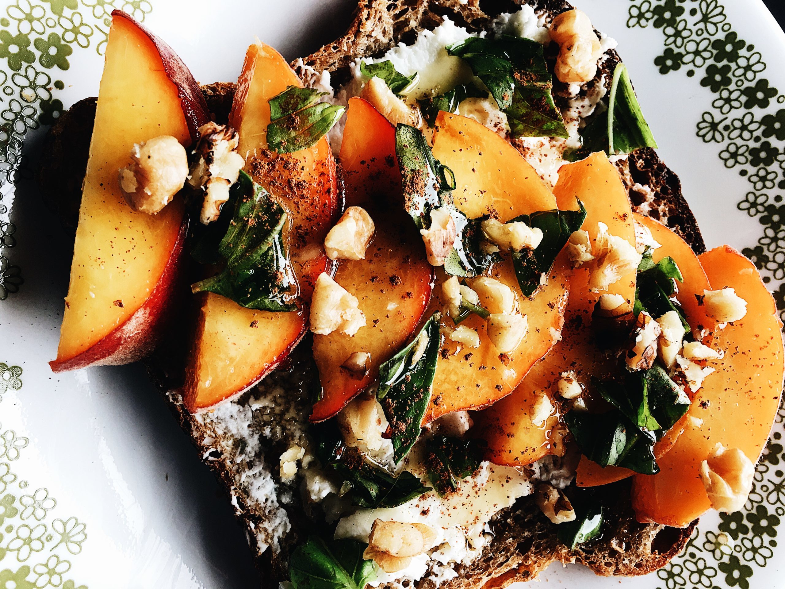 Close up of Basil, Peach and Goat Cheese Toast. Recipe by Alysha Melnyk with Taproot Farm, PA.