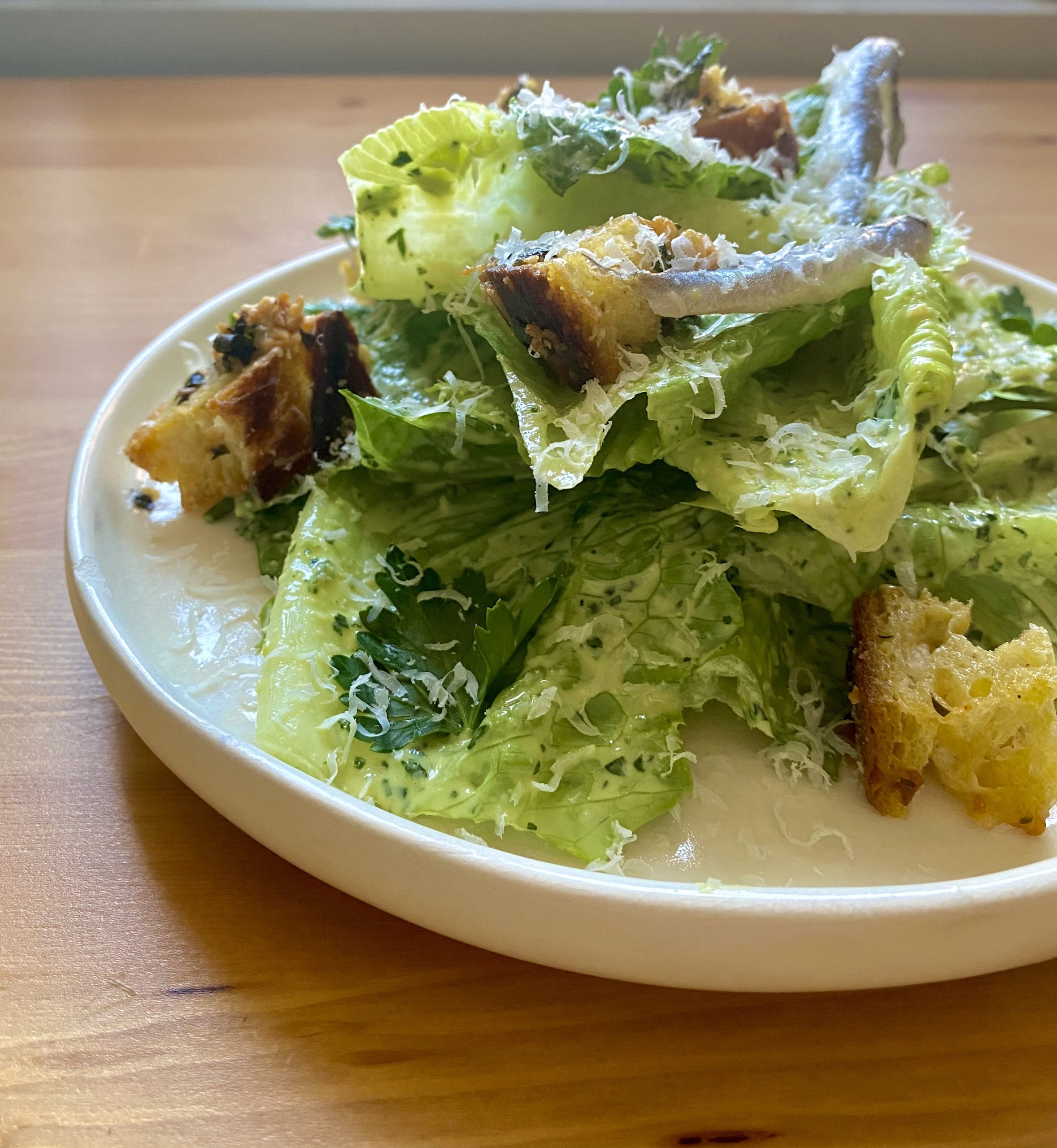A caesar salad with parmesan and croutons.
