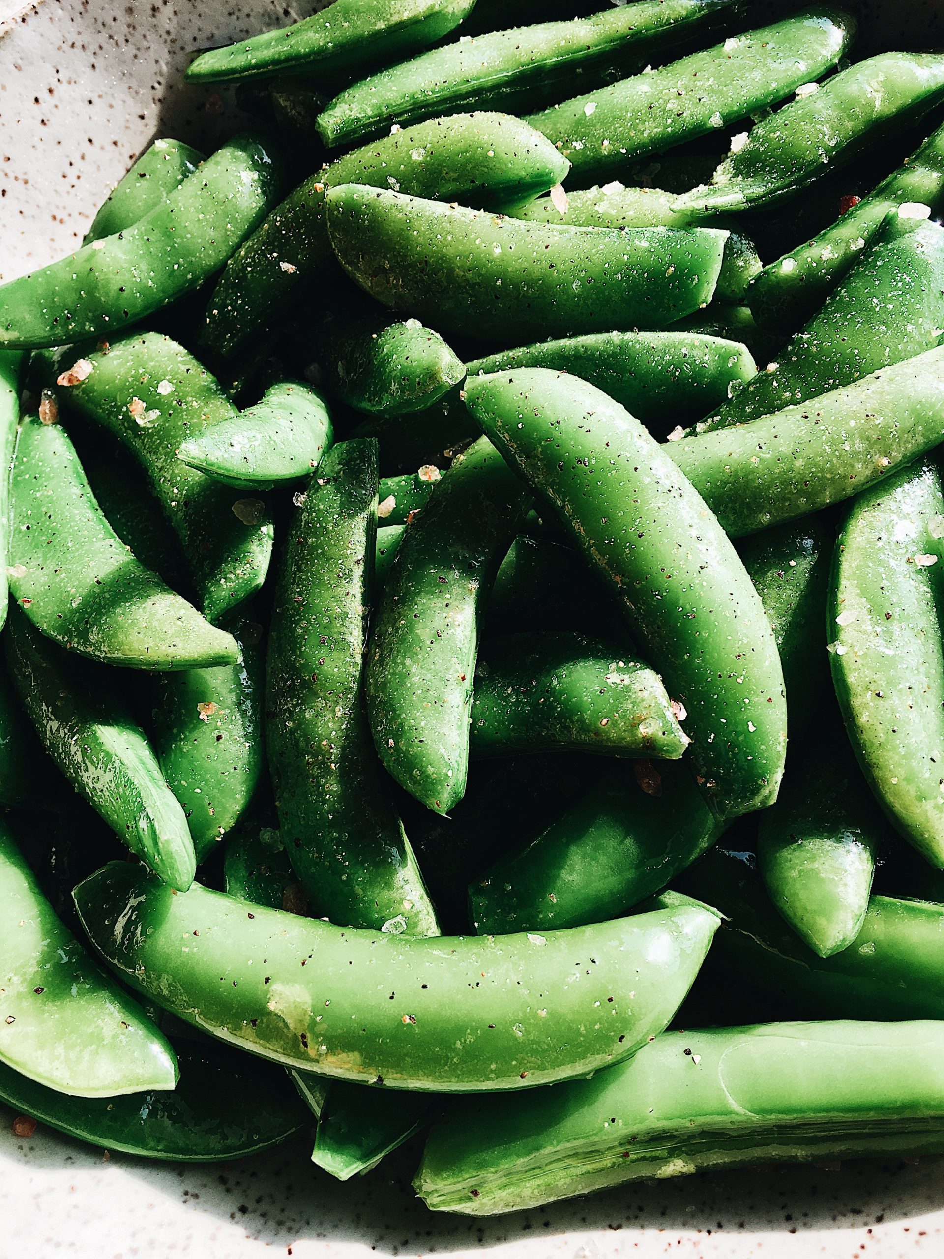 A close up view of sautéed sugar snap peas.